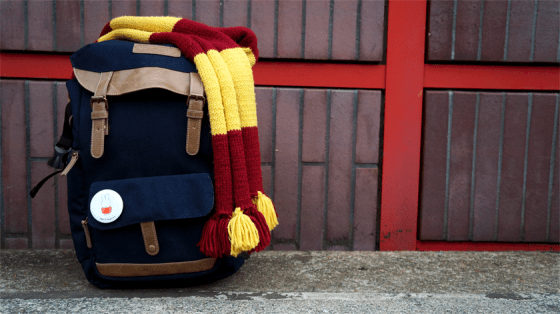 Blauer Rucksack auf dem ein Gryffindor-Schal liegt und an dem ein Miffy-Button befestigt ist.